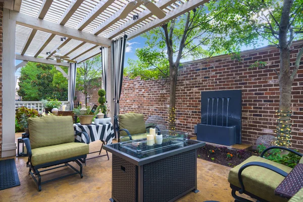 Luxury townhome patio featuring lattice work, tranquil water feature, and shaded outdoor living space in Plano, TX.