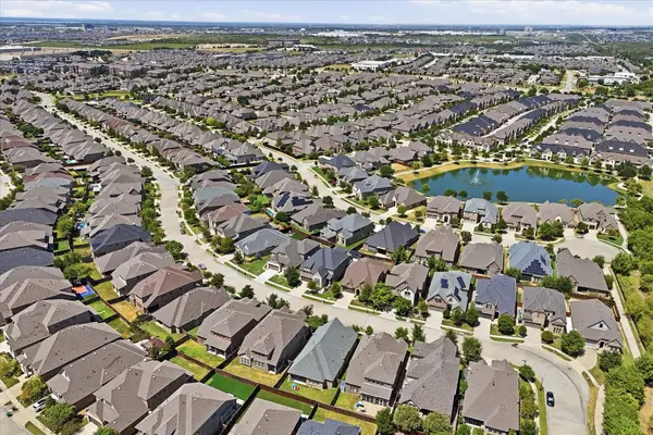 Aerial view of Mustang Park neighborhood in Carrollton, Texas featuring a pond and walking trails