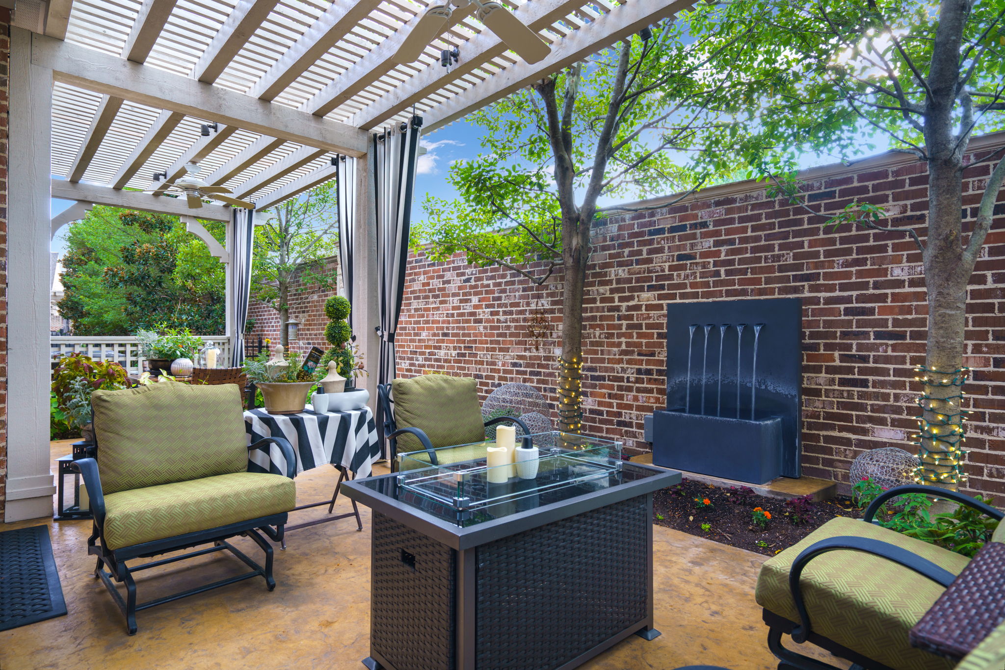Luxury townhome patio featuring lattice work, tranquil water feature, and shaded outdoor living space in Plano, TX.